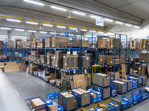 Eine Lagerhalle mit hohen Regalen gefüllt mit großen Verpackungen