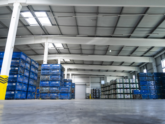 Eine helle Lagerhalle mit hochgestapelten Kisten