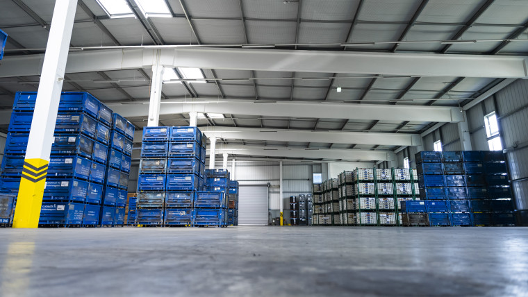Eine helle Lagerhalle mit hochgestapelten Kisten