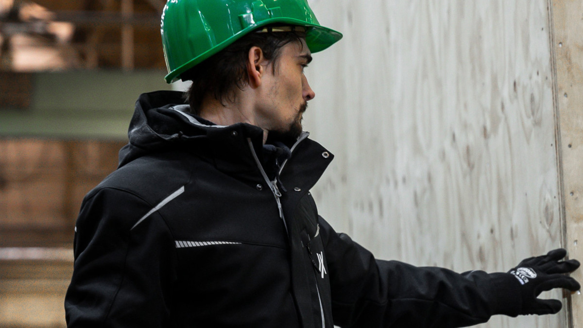 Ein Mann mit einem Helm steht neben einer großen hözernen Exportverpackung