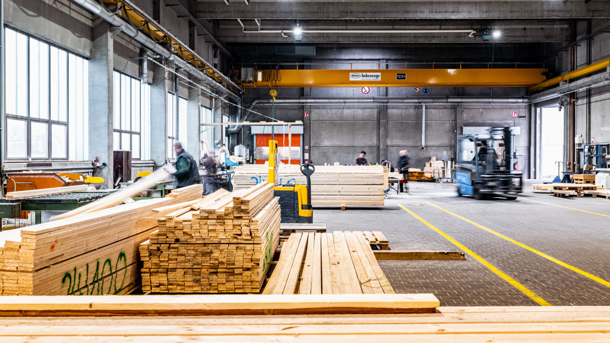 Eine Lagerhalle in der Holzbalken zur Packmittelproduktion lagern.