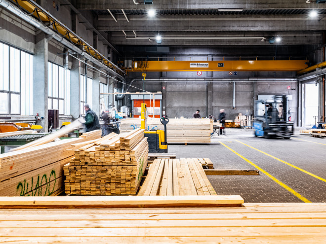 Eine Lagerhalle in der Holzbalken zur Packmittelproduktion lagern.
