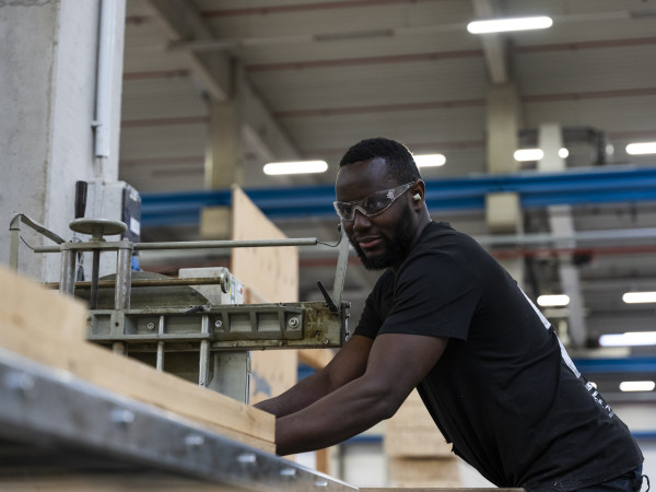 Ein Mann sägt eine Holzplatte