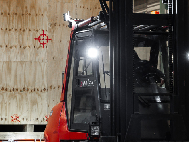 Ein Gabelstapler hebt eine sehr große hölzerne Schwergutverpackung an