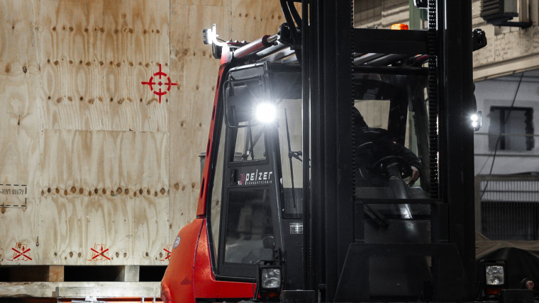 Ein Gabelstapler hebt eine sehr große hölzerne Schwergutverpackung an