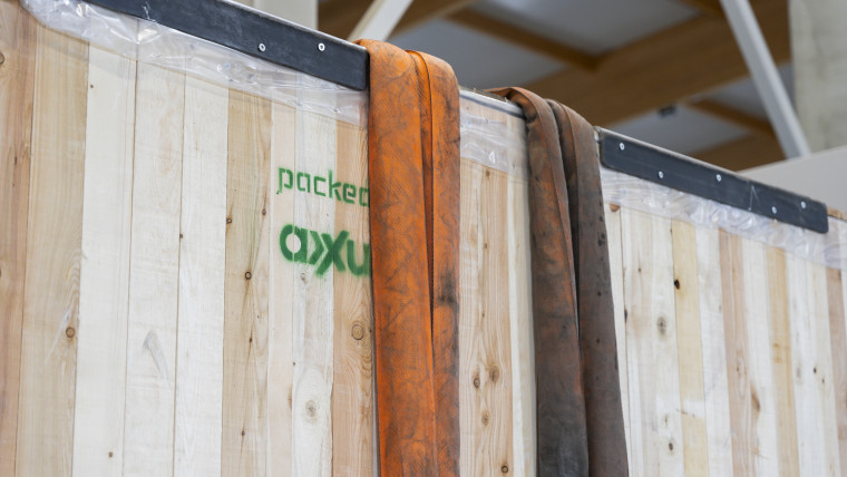 Eine Holzwand mit orangefarbenem und schwarzem Seil, das daran befestigt ist.