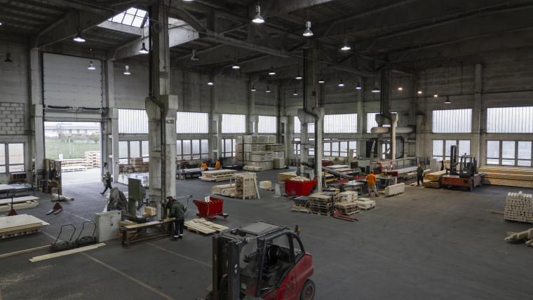 Ein Lagerhaus mit einem Gabelstapler und vielen gestapelten Kisten.