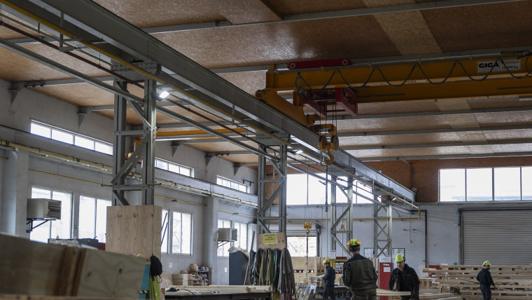 Weitläufiges Lagerhaus, in dem viele Holzlatten und -balken gelagert sind.