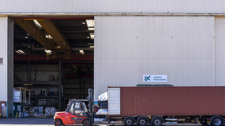 Ein großes Lagerhaus mit einem Gabelstapler, der Waren bewegt.