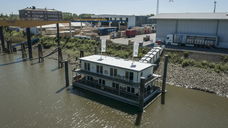 Ein Hausboot ist am Ufer festgemacht und schwimmt auf dem Wasser.