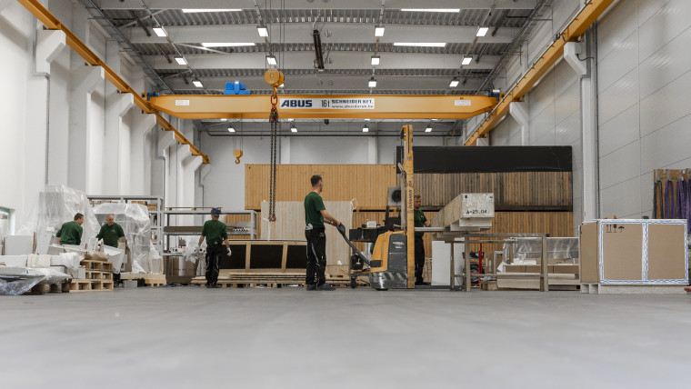 In einem großen Lagerhaus arbeiten Mitarbeiter an der Herstellung von Verpackungen