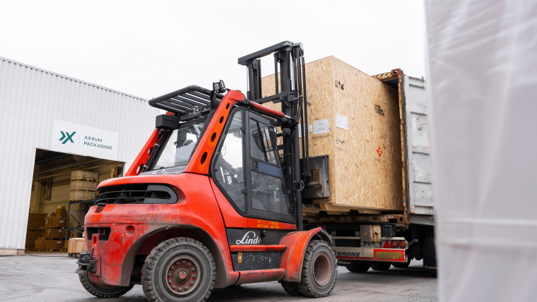 Vor einem Gebäude parkt ein Gabelstapler.