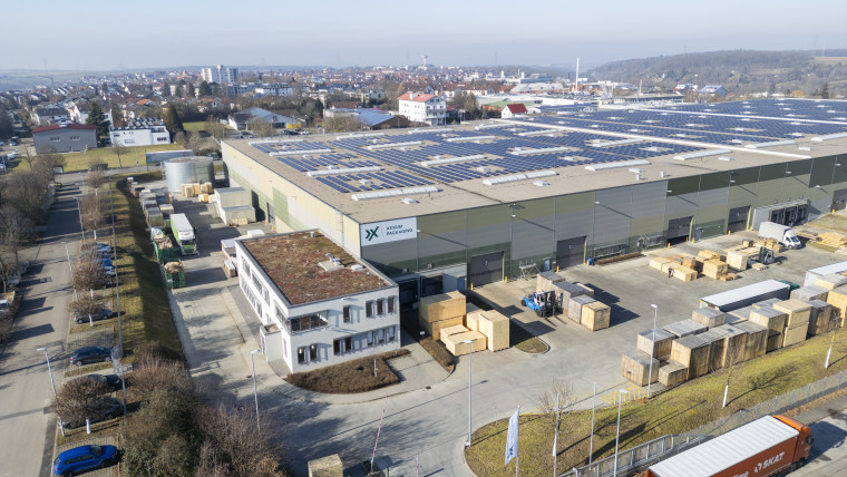Großes Lagergebäude, das mit Solarpanelen auf dem Dach ausgestattet ist.