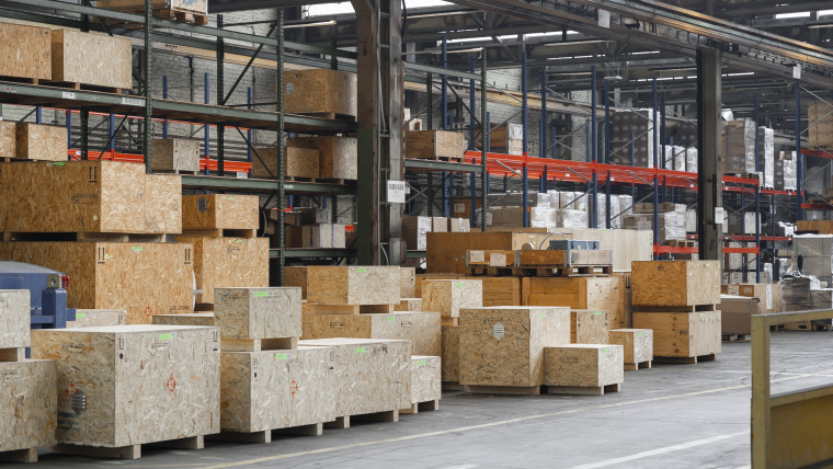 Ein Lagerraum, gefüllt mit Kisten und Paletten, die für den Versand vorbereitet sind.