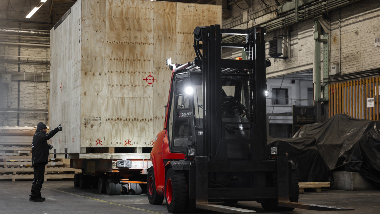 Ein Gabelstapler ist in einem Lagerhaus positioniert, um Waren zu bewegen.