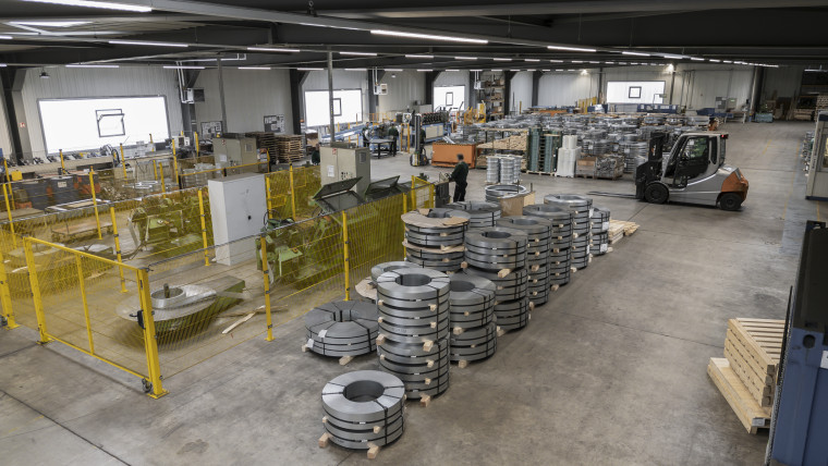 Eine Lagerhalle mit zahlreichen Maschinen und viel Metall, die eine industrielle Umgebung darstellt.