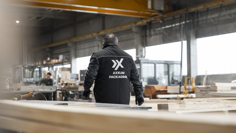 Ein Mann in Arbeitskleidung in einer Fabrik, konzentriert auf seine Aufgaben.