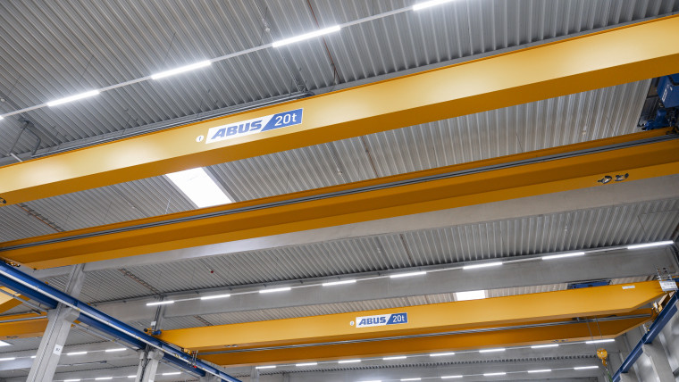 Eine große Überkopfkran in einem Lagerhaus, der für das Heben und Bewegen schwerer Lasten eingesetzt wird.